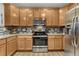 Bright kitchen features stainless steel oven, microwave, and backsplash complemented by light wood cabinets at 7412 S Mobile St, Aurora, CO 80016