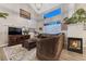 Vaulted living room boasts a fireplace, mounted TV, large windows, and a comfortable seating area at 7412 S Mobile St, Aurora, CO 80016