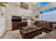 Cozy living room featuring high ceilings, large windows, a wooden entertainment center, and comfortable seating at 7412 S Mobile St, Aurora, CO 80016
