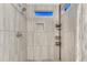 Shower featuring modern tile, shower head, and built-in shelving at 7412 S Mobile St, Aurora, CO 80016