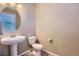 Clean and simple bathroom with a pedestal sink and oval mirror at 20040 E 61St Dr, Aurora, CO 80019