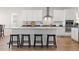 Modern kitchen with white cabinets, stainless steel appliances, island with bar stool seating, and stylish backsplash at 4757 Augustine Ct, Castle Rock, CO 80108