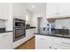 Stylish kitchen featuring granite countertops, double oven, white cabinets, and stainless steel appliances, well-lit at 4757 Augustine Ct, Castle Rock, CO 80108