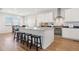 Bright kitchen with white cabinets, granite countertops, stainless steel appliances, island seating, and dining area at 4757 Augustine Ct, Castle Rock, CO 80108