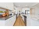 Modern kitchen with white cabinets, granite counters, stainless appliances, a long center island and hardwood floors at 4757 Augustine Ct, Castle Rock, CO 80108