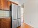 Kitchen features a stainless steel refrigerator, wooden cabinets, backsplash, and wood floors at 1050 S Lewiston Way, Aurora, CO 80017