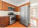 Functional kitchen equipped with stainless steel appliances and wood cabinetry at 1050 S Lewiston Way, Aurora, CO 80017