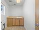 Small, well-lit laundry room with white walls, beige floor tiles, and a built-in sink at 3613 Silverton St, Boulder, CO 80301