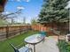 The backyard features artificial turf, a privacy fence, and a patio with an outdoor dining set at 10624 W Berry Pl, Littleton, CO 80127