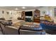 Relax in this finished basement with plush seating, a large tv, and custom bookshelves at 10624 W Berry Pl, Littleton, CO 80127
