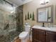 Bathroom with stone shower, glass door, and stylish vanity at 10624 W Berry Pl, Littleton, CO 80127