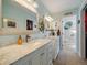 Bathroom with dual vanities, marble countertops, and decorative mirrors at 10624 W Berry Pl, Littleton, CO 80127
