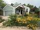 Charming home with a lush front yard featuring vibrant flowers and an American flag at 10624 W Berry Pl, Littleton, CO 80127