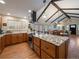 Open-concept kitchen with vaulted ceilings, wooden beams, and island with granite countertops at 10624 W Berry Pl, Littleton, CO 80127