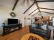Open-concept living room with vaulted ceiling, hardwood floors, and an electric fireplace at 10624 W Berry Pl, Littleton, CO 80127