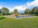 Community playground features fun equipment surrounded by lush green grass and shady trees at 10624 W Berry Pl, Littleton, CO 80127