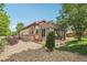 Well-maintained home exterior featuring a gravel yard, lush greenery, and a charming pergola-covered patio at 2864 S Jebel Way, Aurora, CO 80013
