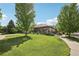 Landscaped front yard featuring a charming covered porch and beautiful greenery, enhancing the home's curb appeal at 2864 S Jebel Way, Aurora, CO 80013