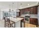 Modern kitchen featuring stainless steel appliances, granite countertops, a large island, and dark wood cabinetry at 2864 S Jebel Way, Aurora, CO 80013