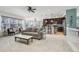 Open-concept living room with a ceiling fan, carpet, and a seamless flow into the adjacent kitchen and dining areas at 2864 S Jebel Way, Aurora, CO 80013
