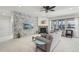 Cozy living room with a stone accent wall, fireplace, ceiling fan, and large windows providing natural light at 2864 S Jebel Way, Aurora, CO 80013