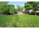 View of the home from the backyard showcasing mature trees and a lawn at 11625 Bellaire Way, Thornton, CO 80233