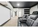 Finished basement with a home theater setup, including comfortable seating and a large projection screen at 11625 Bellaire Way, Thornton, CO 80233