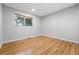 Bright bedroom features light gray walls, wood floors, and a window with blinds at 11625 Bellaire Way, Thornton, CO 80233