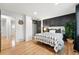 Stylish bedroom with a modern accent wall, hardwood floors, and a barn door closet at 11625 Bellaire Way, Thornton, CO 80233