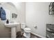 Well-lit half-bathroom with pedestal sink, toilet, and modern fixtures at 6954 E 117Th Ave, Thornton, CO 80233