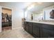 Bathroom featuring double sinks, a large mirror, and a walk-in closet for ample storage at 6954 E 117Th Ave, Thornton, CO 80233