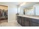 Bright bathroom features a double vanity, a tile floor, and a separate door to a walk in closet at 6954 E 117Th Ave, Thornton, CO 80233