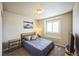 Bedroom featuring a window with shutters, a side table, and neutral decor at 6954 E 117Th Ave, Thornton, CO 80233