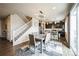 Open dining area with contemporary lighting, adjacent to the staircase and a modern kitchen at 6954 E 117Th Ave, Thornton, CO 80233