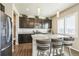 Modern kitchen features granite countertops, dark cabinetry, stainless steel appliances, and a breakfast bar at 6954 E 117Th Ave, Thornton, CO 80233
