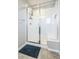 Bright bathroom features a glass-enclosed shower with white tile and convenient built-in shelving at 6954 E 117Th Ave, Thornton, CO 80233