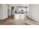 Modern kitchen features white cabinets, stainless appliances, island with sink and hardwood flooring at 2974 Oxley St, Strasburg, CO 80136