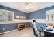 This bedroom features soft blue walls, white trim, carpet floors, ceiling fan and a window overlooking the well manicured lawn at 10247 Telluride Way, Commerce City, CO 80022