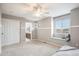 This primary bedroom features neutral paint, carpet floors, ceiling fan and a window seat with an attached en-suite bathroom at 10247 Telluride Way, Commerce City, CO 80022