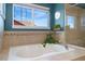 Elegant bathroom with soaking tub, mounted TV, and lots of natural light at 4464 E 139Th Ave, Thornton, CO 80602