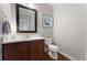 Modern half bathroom with stylish dark vanity, white countertop, decorative mirror and hardwood floors at 4464 E 139Th Ave, Thornton, CO 80602