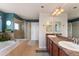 Bright bathroom with double vanity, soaking tub, and separate glass shower at 4464 E 139Th Ave, Thornton, CO 80602