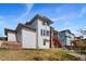 Back exterior of home features a deck, fire pit, and well-kept lawn with beautiful blue sky at 4464 E 139Th Ave, Thornton, CO 80602