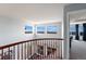 Bright upstairs hallway featuring lots of light, banister, and a view into another room at 4464 E 139Th Ave, Thornton, CO 80602