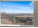 Window view of neighborhood rooftops with open plains and skyline visible in the background at 4464 E 139Th Ave, Thornton, CO 80602