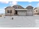 Two-story house with gray siding, stone accents, and a three-car garage at 4125 River Oaks St, Castle Rock, CO 80104