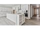 Modern kitchen with white cabinets, island, and stainless steel appliances at 4125 River Oaks St, Castle Rock, CO 80104