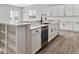 Kitchen island with white cabinets, quartz countertop, and a built-in sink at 4125 River Oaks St, Castle Rock, CO 80104