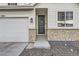Welcoming front entrance with stone accents, a black front door with wreath, and tidy landscaping at 13362 Amber Sky St, Parker, CO 80134