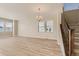 Bright living room featuring hardwood floors, a staircase, and elegant lighting fixtures, offering ample space at 13362 Amber Sky St, Parker, CO 80134